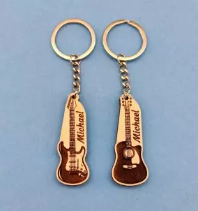 A photo of the personalized acoustic and electric guitar keychains with custom name on the blue background.
