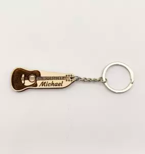 Personalized Keychain in the shape of an acoustic guitar with a custom name engraved on it.