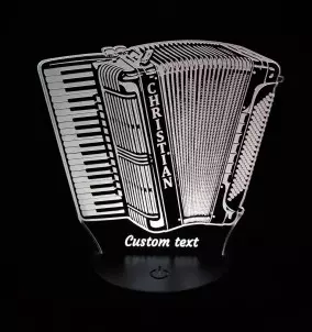 Personalisierte 3D-LED-Lampe in Form eines Piano-Akkordeons, das in weißer Farbe leuchtet und auf einem Nachttisch sitzt.