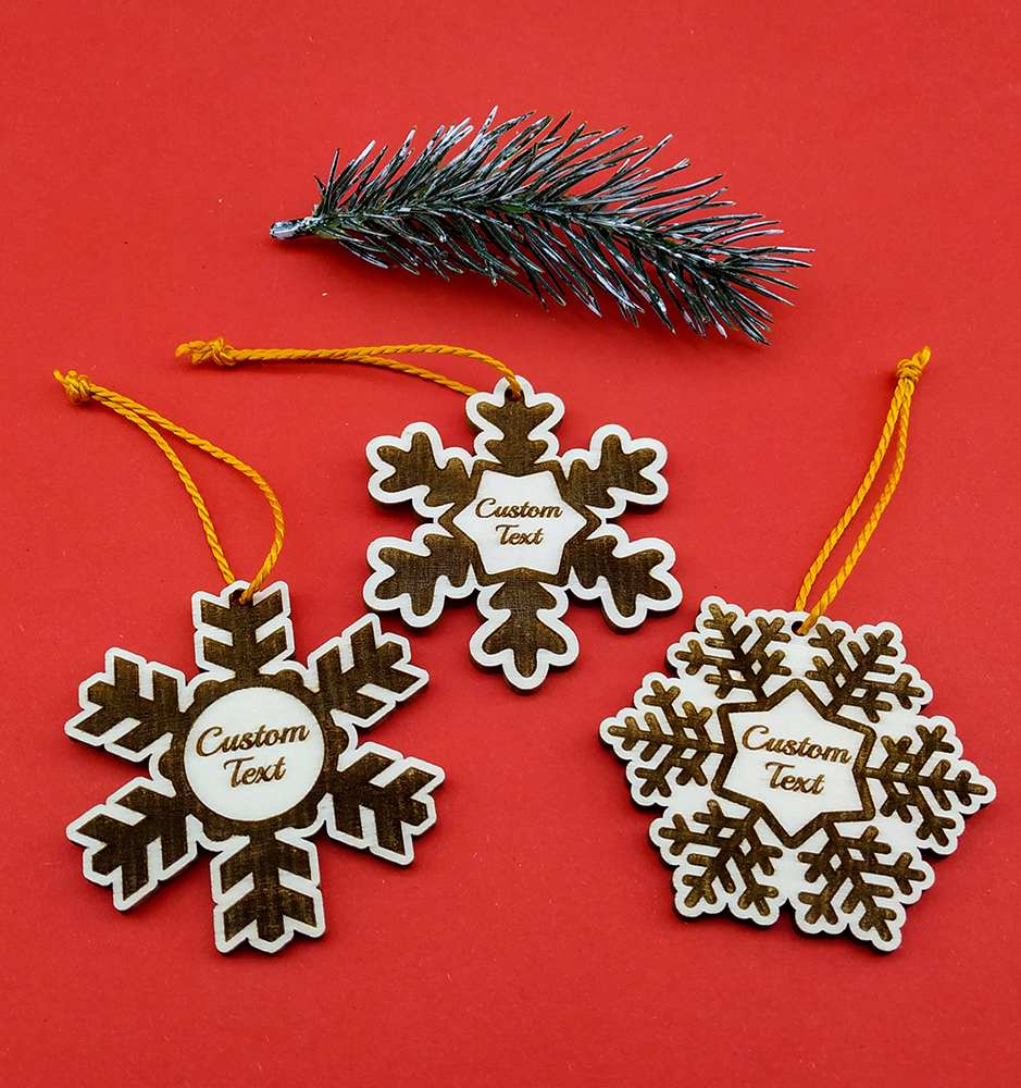 Personalisierter Weihnachtsschmuck in Form einer Schneeflocke mit individueller Textgravur.